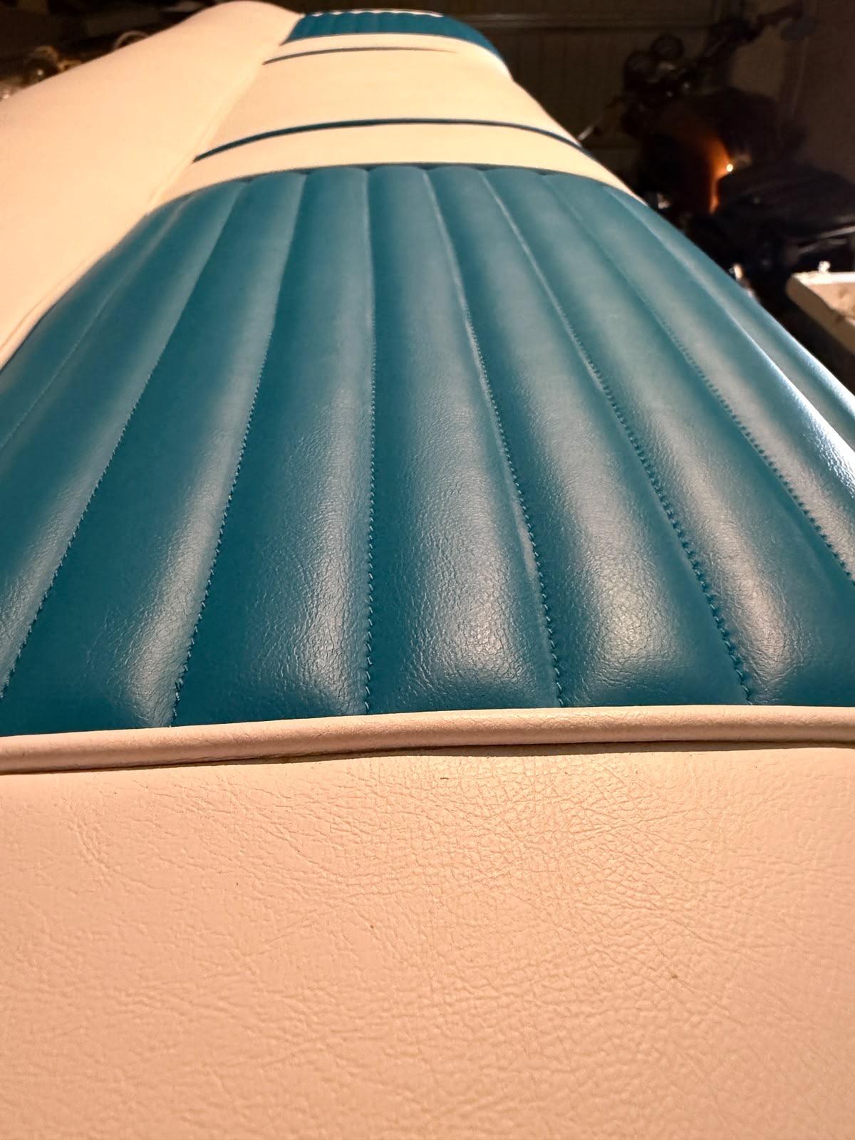 Banquette de véhicule ancien recouverte de simili turquoise et ivoire à baguettes