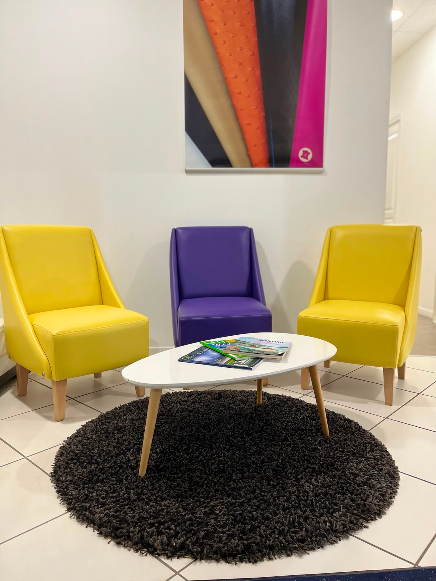 Salon d'attente équipé de fauteuils regarnis en simili jaune et violet